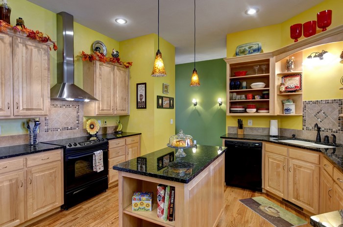 Kitchen with light wood cabinets and yellow walls