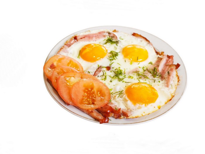 Fried eggs with bacon and tomatoes on a plate