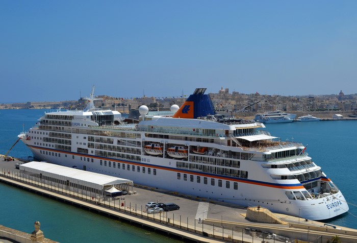 MS Europa cruise ship docked in a harbor with a city in the background