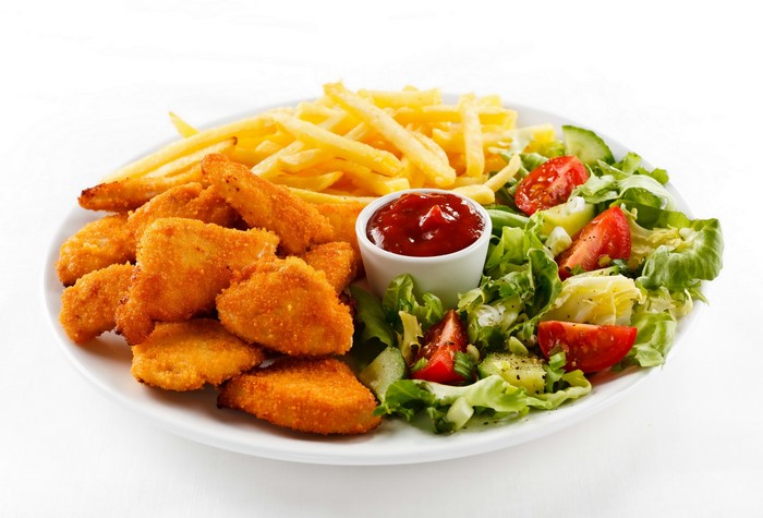 Chicken nuggets with french fries, salad, and ketchup