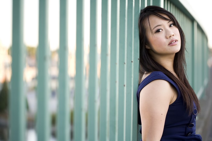 Maggie Ma leaning on a green fence