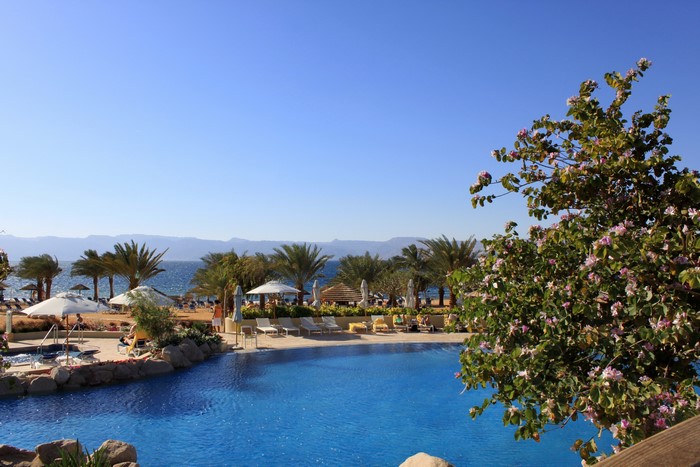 Resort pool and beach with palm trees in Eilat, Israel