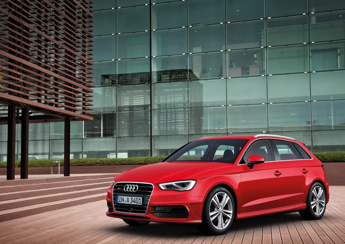 Red Audi A3 Sportback in front of modern building