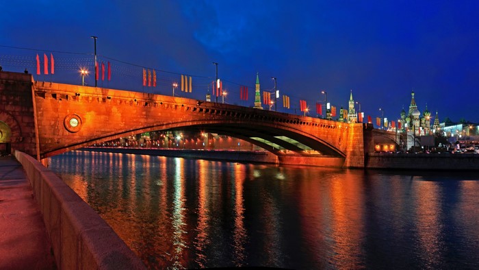 Bridge over river at night with Moscow skyline