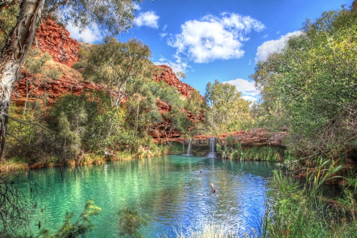 Turquoise pool with waterfalls and red rock cliffs