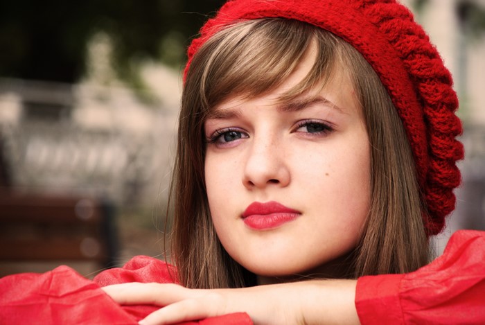 4K portrait of a young woman with brown hair wearing a red hat