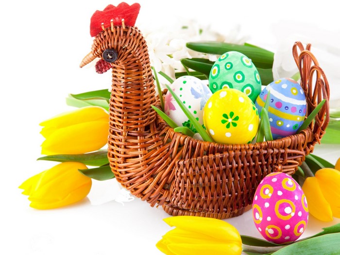 Easter wicker basket with decorated eggs and tulips