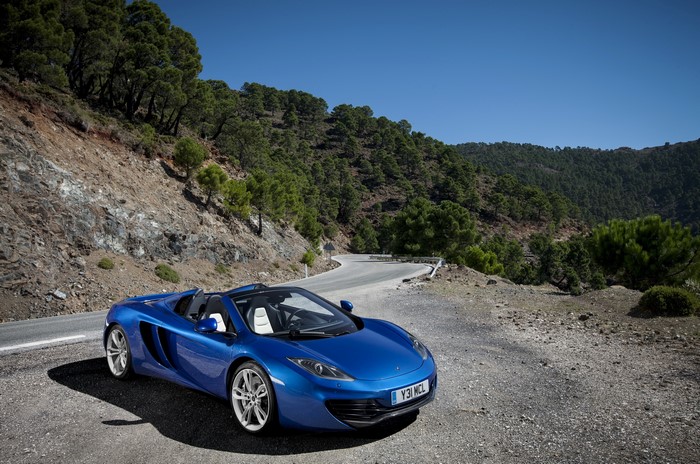 Blue 2012 McLaren 12C Spider Cabriolet on a mountain road