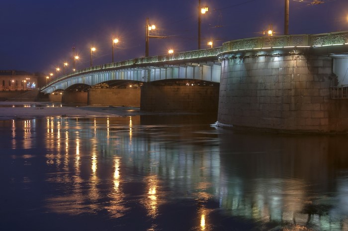 Bridge at night with street lights reflecting on water