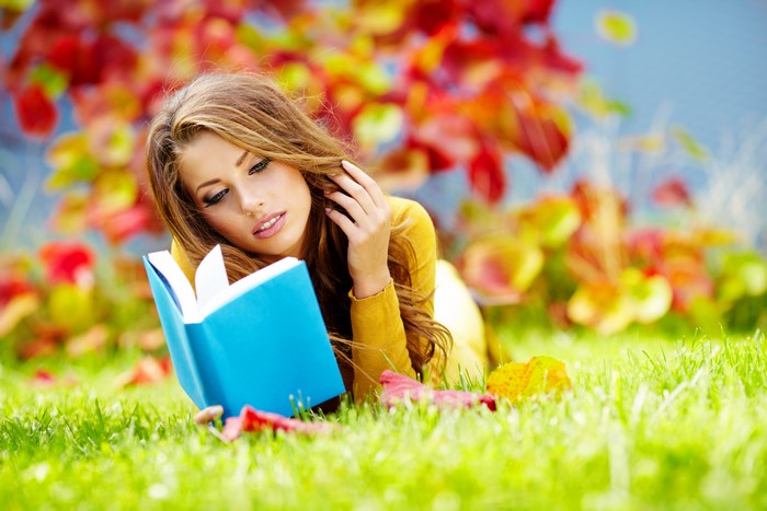 Woman reading a book in autumn