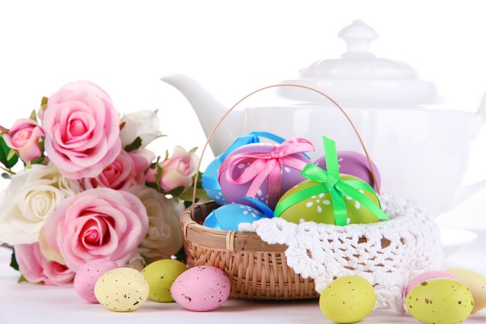 Easter eggs in a basket with roses and teapot