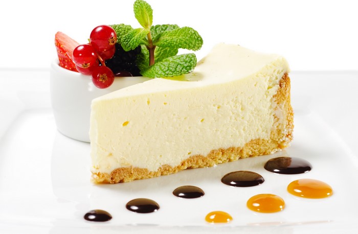 Slice of cheesecake with berries and chocolate sauce