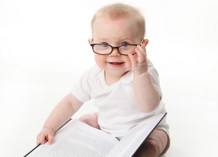 Baby wearing glasses reading a book
