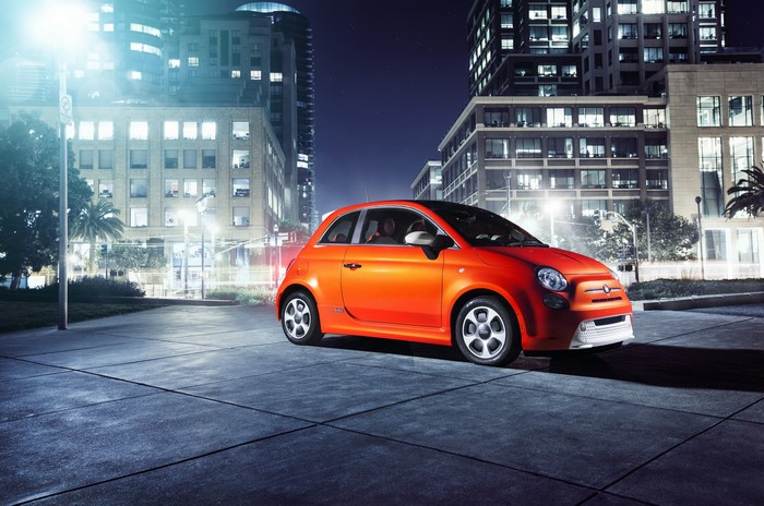 Orange 2013 Fiat 500e parked at night in a city