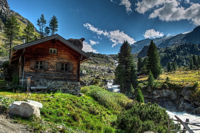 Wooden cabin by a mountain stream in the Alps