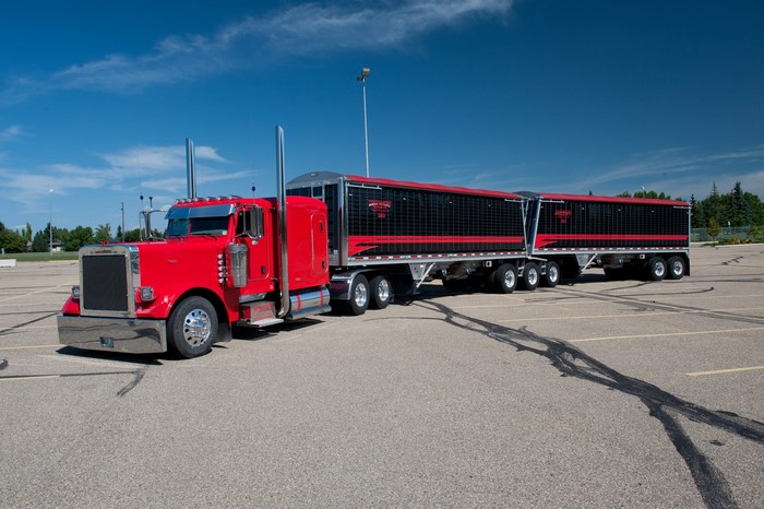 Red Peterbilt truck with double trailers