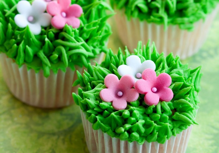 Cupcakes decorated with green frosting and flowers