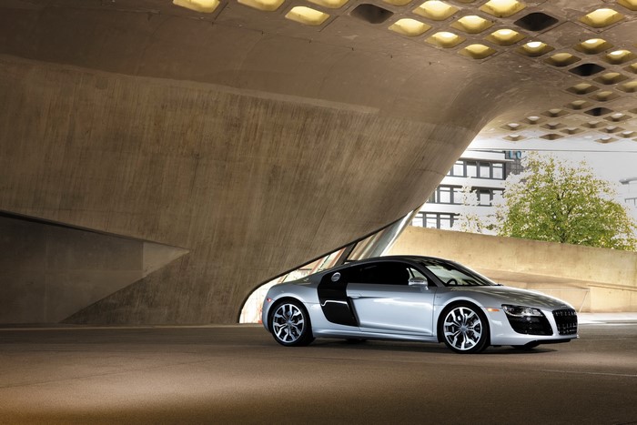 Silver Audi R8 Quattro parked under a modern concrete structure