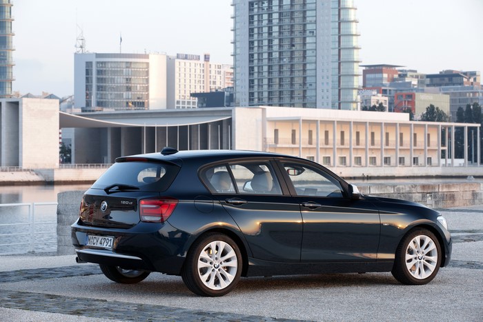 BMW 120d Urban Line parked by a waterfront with modern buildings