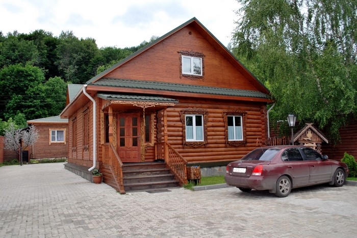 Wooden house in Russia with a car