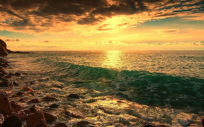 Sunset over the ocean with rocky shore
