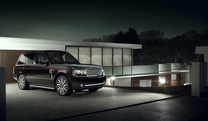 2011 Range Rover parked in front of modern house at night