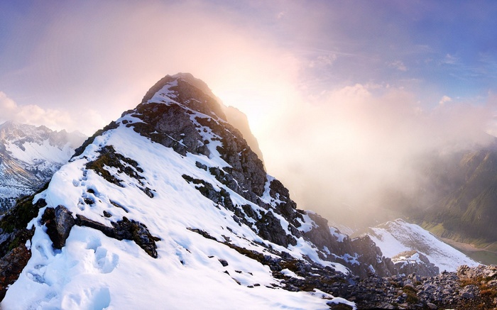 Snowy mountain ridge with sunlit clouds