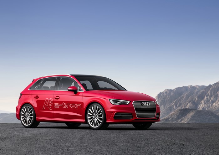 Red Audi A3 e-tron parked on asphalt with mountains in background