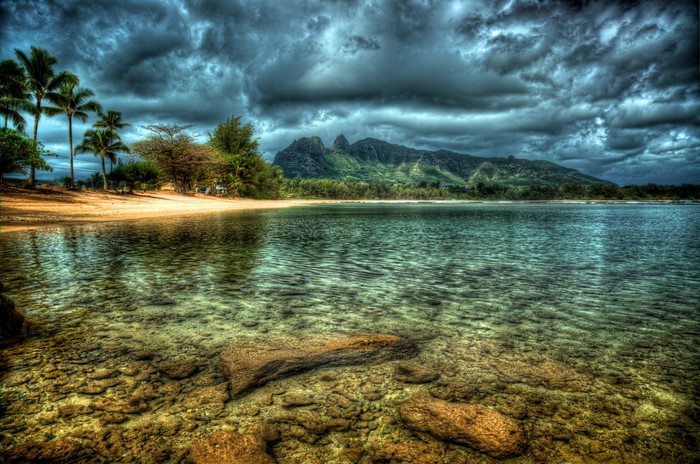Tropical beach with mountains and stormy clouds