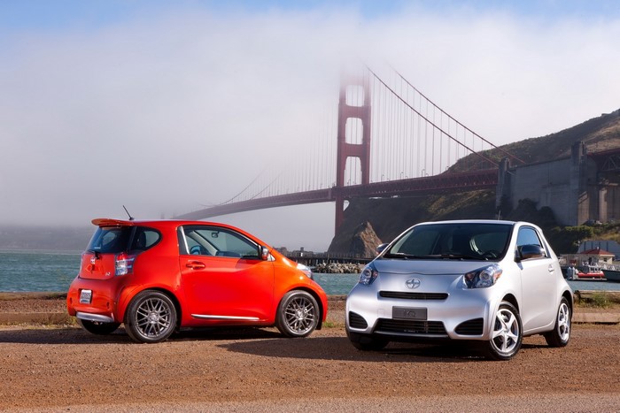 Two Scion iQ cars parked near the Golden Gate Bridge
