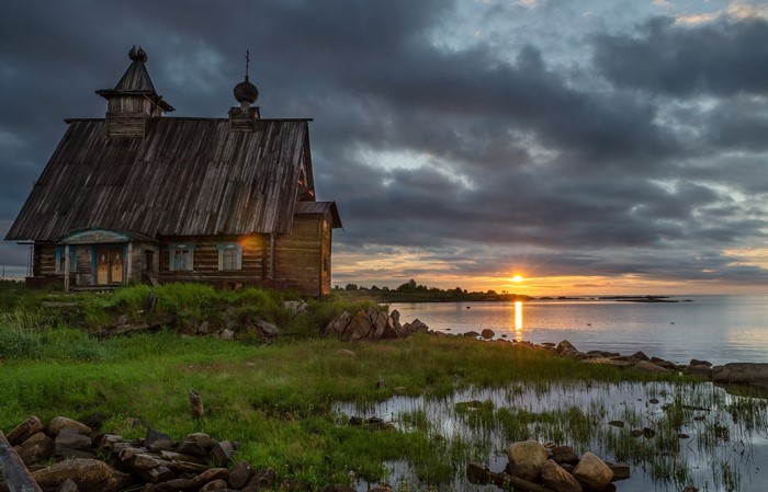 Wooden church by the sea at sunset