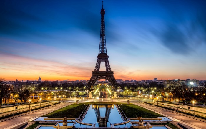 Eiffel Tower at sunset with city skyline and reflection