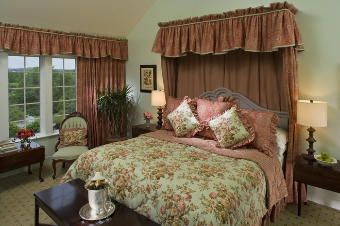 Bedroom with floral bedding and canopy bed