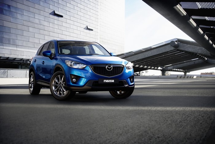 Blue Mazda CX-5 parked in front of a modern building