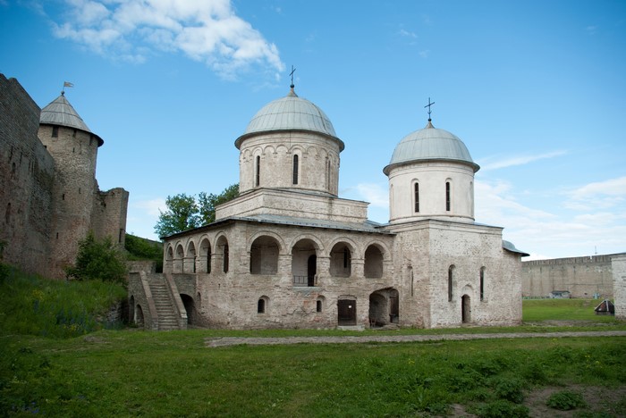 Ancient stone fortress and church with domes under blue sky