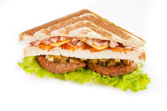 Triangular sandwich with bacon, cheese, and pickles
