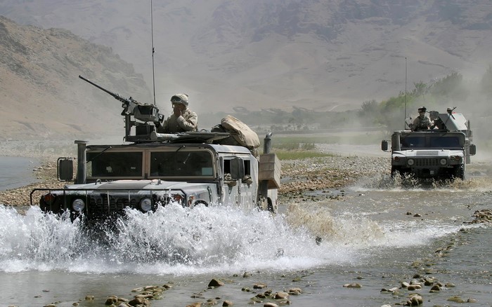 Military Humvees driving through a river