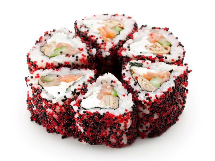 Sushi rolls with salmon, cucumber, and egg, covered in tobiko