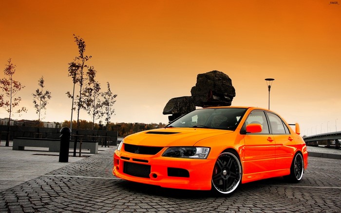 Orange Mitsubishi Lancer Evolution on Pavement