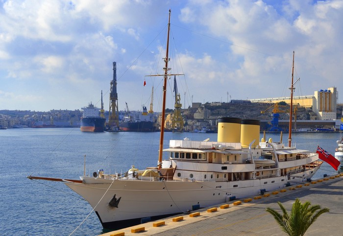 Classic Yacht Talitha docked in a harbor with cranes