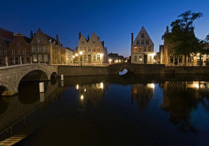 Bruges canal at night with illuminated houses and bridges