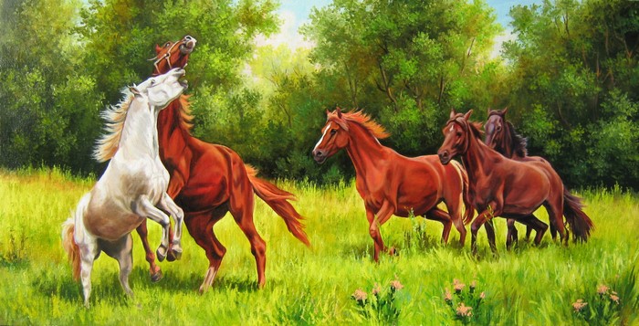 Horses playing in a grassy field with trees