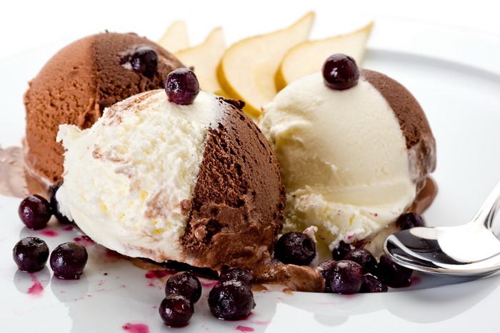 Chocolate and vanilla ice cream scoops with blueberries and pear slices