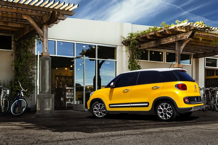 Yellow 2013 Fiat 500L Trekking parked outside building