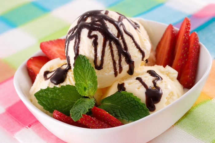 Vanilla ice cream with chocolate syrup and strawberries