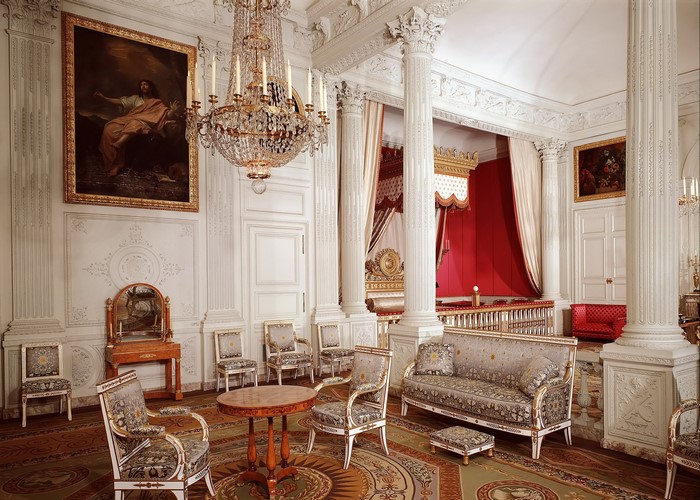 Ornate room with a bed, sofa, chairs, and chandelier