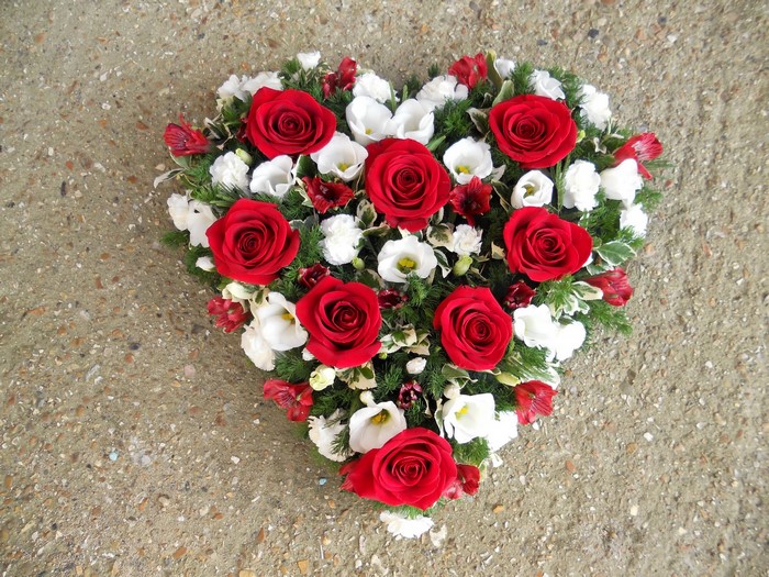 Heart-shaped floral arrangement with red roses and white flowers