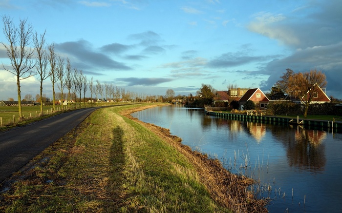 Canal with houses and trees along the road