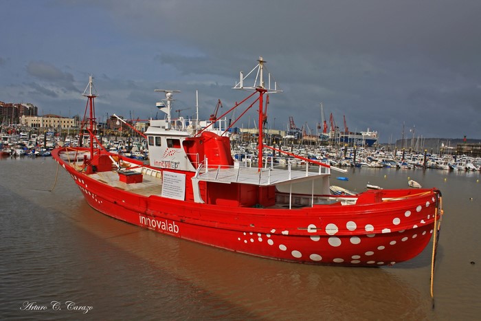 Red fishing boat with white polka dots in Bilbao harbor