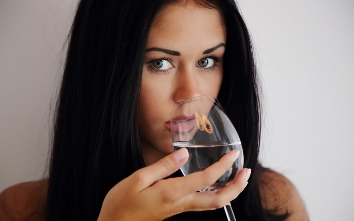Brunette girl drinking from a glass